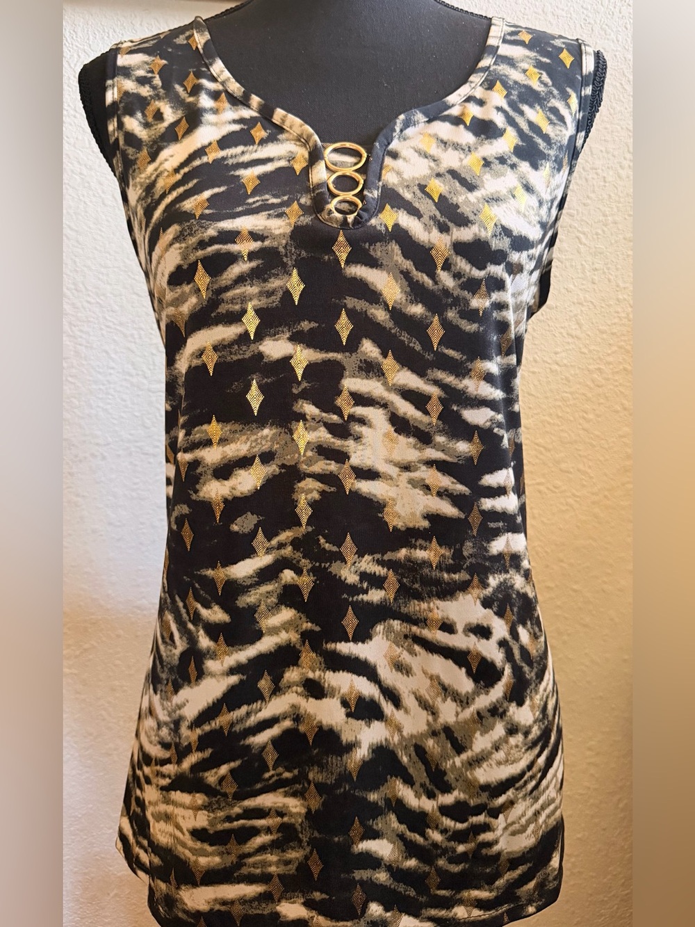 Women's sleeveless top with gold ring accent on animal print.